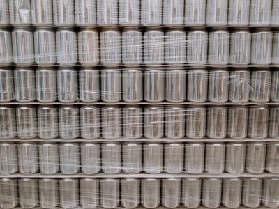 Rows of empty metal cans wrapped in plastic film.